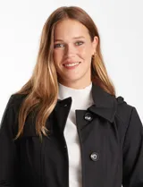 Gabardina trench de color beige, confeccionada en tejido repelente al agua. Presenta cuello con solapa ancha, cierre frontal con botones en tono carey, cintura con lazo de ajuste y bolsillos laterales tipo ojal. Incluye capucha desmontable y forro interno a tono.