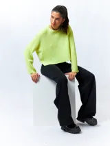 Sweater color crema de tejido de punto acanalado, corte cropped, cuello redondo y mangas largas.