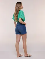 Short de denim blanco tiro alto, estilo pull-on con cintura elástica ancha, bolsillos delanteros y traseros, y dobladillo en las piernas.