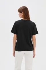 Remera de algodón blanca, de manga corta y cuello redondo, con estampado frontal de texto en color negro.