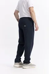 Pantalón de jogging color beige, confeccionado en algodón y poliéster, con cintura elástica y cordón ajustable. Diseño clásico sin puño en los tobillos.