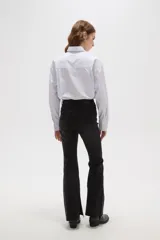 Pantalon jean de corte oxford, color negro, con tiro medio y ruedo deshilachado.