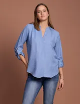 Blusa celeste con escote en V y mangas 3/4 regulables con presilla y botón.