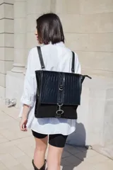 Mochila de cuero vacuno color negro, con tapa de cuero con textura croco color bordó y detalles en blanco. Tiene mosquetón de seguridad exterior, cierre interior, dos bolsillos interiores (uno con cierre y otro para celular), sujetador de llaves, forro completo y tiras ajustables. Se puede usar como mochila o como cartera.