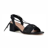 Sandalia de cuero sintético negro con tiras trenzadas, taco bloque y ajuste con tiras para atar al tobillo.