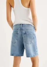 Bermuda de jean azul claro, tiro medio, corte recto y holgado, con largo por encima de la rodilla.