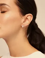 Aro piercing plateado con forma circular y una perla blanca en el centro.