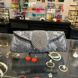 Sobre de fiesta dorado con bordado de mostacillas y lentejuelas. Tiene asa de cadena dorada para colgar al hombro.