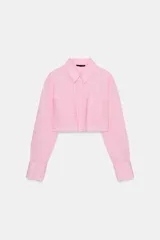 Camisa corta rosa con rayas verticales finas, cuello solapa, manga larga y bolsillos delanteros de plastrón. Cierre frontal con botones ocultos.