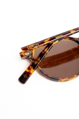 Lentes de sol polarizados con armazón carey de diseño redondo y lentes marrones.
