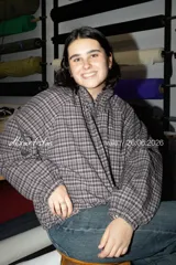 Top de cuello alto y manga larga confeccionado en tejido de malla semitransparente con estampado artístico abstracto en tonos rojizos, negros y blancos.