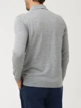 Sweater de punto fino color gris melange, con cuello camisero y cierre frontal de tres botones. Presenta mangas largas con puños ajustados y un pequeño aplique decorativo en el ruedo.