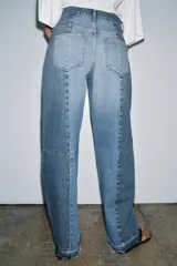 Jeans de tiro medio con diseño barrel y detalle de patchwork en denim a contraste. Cuenta con cinco bolsillos, trabillas en la cintura y cierre frontal con cremallera y botón.