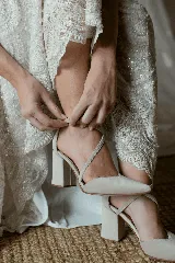 Zapato de tacón ancho color rosa viejo, de tela tipo terciopelo, con puntera fina y tiras cruzadas sobre el empeine.