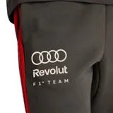 Pantalon de jogging adidas color negro, con cintura elástica y cordón ajustable. Presenta el logo de Audi F1 Team en la pierna derecha y el logo de adidas en la izquierda, con franjas laterales en color rojo.