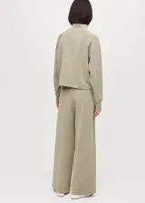 Pantalón de pierna ancha color verde militar, confeccionado en tejido de modal, poliéster y elastano, con cintura elástica con cordón ajustable y bolsillos laterales.