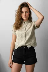 Camisa holgada de algodón color beige con bordado tipo broderie inglés en toda la prenda y mangas cortas.