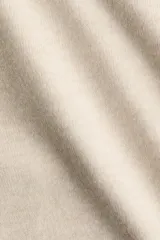 Sweater de punto suave color beige, con cuello redondo, mangas largas con frunces en los hombros y terminaciones acanaladas en cuello, puños y bajo.