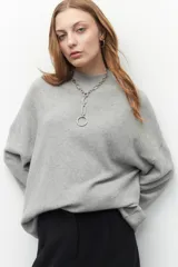 Polera tejida color borgoña, de cuello alto y mangas largas abullonadas con detalle de bordado trenzado en los puños.