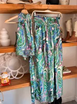 Conjunto de dos piezas color fucsia con estampado oriental en tonos rosa y blanco, compuesto por un top halter con lazo en la cintura y un pantalón palazzo de cintura alta con elástico.