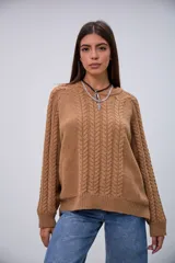 Sweater de punto color camel con cuello redondo, mangas largas y diseño de trenzas en el frente y las mangas.