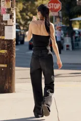 Jeans de mezclilla en color negro con efecto lavado, de tiro alto y cinco bolsillos, con perneras extra anchas y cierre frontal con cremallera y botón metálico.