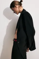 Blazer marrón de cuello solapa con muescas, manga larga y bolsillos de vivo con solapa. Cierre frontal con un botón.