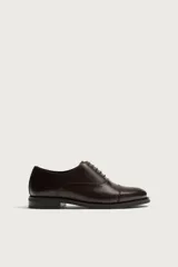 Zapato de vestir tipo oxford con puntera reforzada, confeccionado en piel de color marrón oscuro. Presenta cierre mediante cordones al tono, forro interior y plantilla de piel, y suela a contraste con tacón bajo.