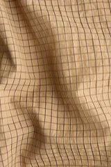 Camisa de corte relajado en tejido dobby con estampado de cuadros, cuello con detalle de moña y botonadura frontal. Presenta hombros caídos y mangas largas con puños abotonados.