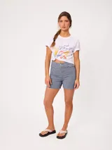 Remera celeste de corte holgado, con cuello redondo, manga corta y estampado frontal colorido de temática costera.