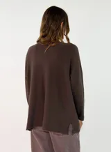 Sweater de punto color verde oliva, con cuello redondo, mangas largas y diseño holgado con costuras visibles en los laterales.