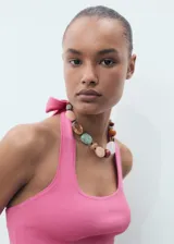 Top Dean de punto fino color rosado, sin mangas, con cuello halter y escote cuadrado.