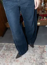 Jean de corte wide leg en color azul oscuro, con diseño de costuras diagonales en la parte frontal y tiro medio.