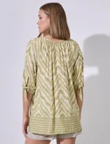 Blusa estampada con cuello redondo y abertura central con botones. Manga corta con lazo.