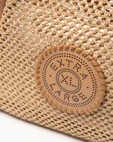 Cartera tipo tote de diseño tejido tipo red color tostado, con asas y detalles en cuero sintético del mismo tono. Incluye un aplique circular frontal perforado con el logo de la marca.