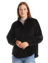Sobrecamisa de pana con textura acanalada, corte oversize y silueta holgada. Presenta cuello clásico, cierre frontal con botones metálicos, mangas largas con puños abotonados y dos bolsillos frontales tipo parche con solapa.