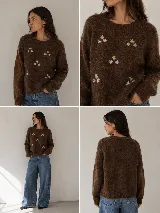 Sweater de punto con textura suave y diseño de flores bordadas dispersas. Presenta cuello redondo, mangas largas y puños acanalados.
