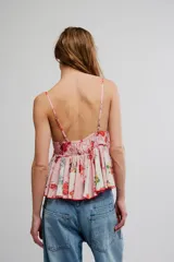 Top estilo babydoll de viscosa color rosado con estampado floreado, escote en V pronunciado, tirantes finos y detalles de volados combinados con paneles en tono crudo.