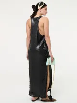 Vestido largo de corte recto con escote redondo y tirantes anchos, completamente cubierto de lentejuelas brillantes. Presenta tajos laterales en el ruedo.