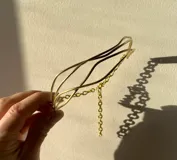 Gargantilla de metal dorada con cuatro hilos irregulares y cadena regulable.