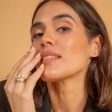 Anillo de oro blanco 18K con diseño medio sin fin, decorado con una línea de circonias engastadas en el frente.