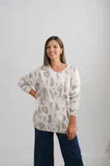 Sweter de punto con diseño estampado en tonos visón y detalles metalizados, de corte holgado, escote en V y manga larga.