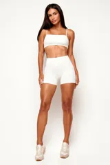Short deportivo de cintura alta y diseño ajustado, color blanco crema, confeccionado en poliamida sin costura frontal.