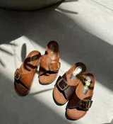 Sandalias de cuero color marrón con hebilla dorada y plantilla de cuero.