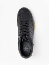 Champion de cuero sintético color negro con cordones al tono y suela de goma color caramelo.