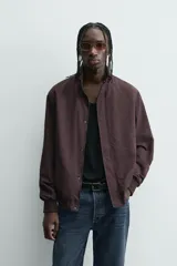 Cazadora azul marino de corte regular fit, confeccionada en tejido técnico repelente al agua. Presenta cuello subido, manga larga, bolsillos de vivo en cadera, bolsillo interior y acabados en rib en puños y bajo. Cierre frontal de cremallera oculta por solapa con botones a presión.