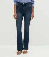 Pantalón bootcut de tiro alto confeccionado en jean de algodón con elastano. Presenta trabillas en la cintura, cierre frontal con botón, bolsillos clásicos con bolsillo reloj y bajo acampanado.