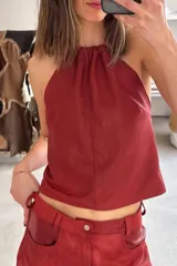 Top halter color bordó de cuero napa, con cuello fruncido y diseño sin mangas.