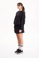 Campera deportiva negra de corte bomber sin friza, con cierre frontal completo, capucha y elásticos ajustables en la cintura.