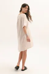 Vestido corto color arena de lino, con cuello en V y mangas cortas.